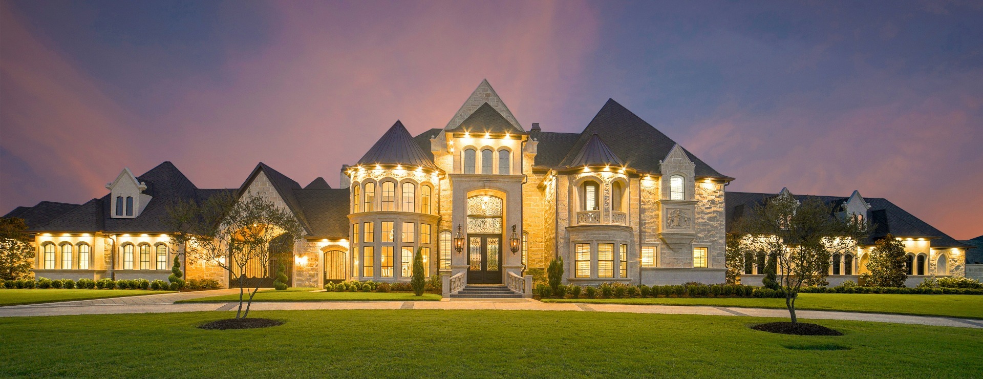 Luxury equine estate with stone manor, white-fenced paddocks and stable at golden hour